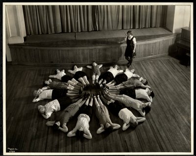 Jonge blinde vrouwen liggend in een sterpatroon op de vloer van de gymzaal bij de New York Association for the Blind, 111 East 59th Street, New York, 1933 door Byron Company
